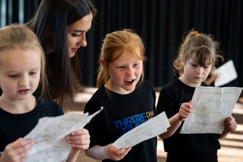 Young people expressing creativity through acting, singing and dancing at Theatretrain