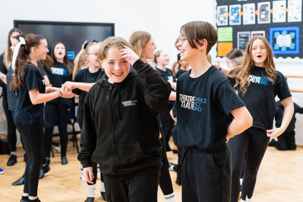 Children taking part in a Theatretrain rehearsal room session, building confidence through acting, singing and dancing.