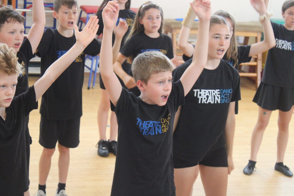 Young performers preparing for a Theatretrain rehearsal, learning to turn nerves into excitement.